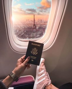 mujer en un avión, mostrando su pasaporte con la Torre Eiffel de fondo