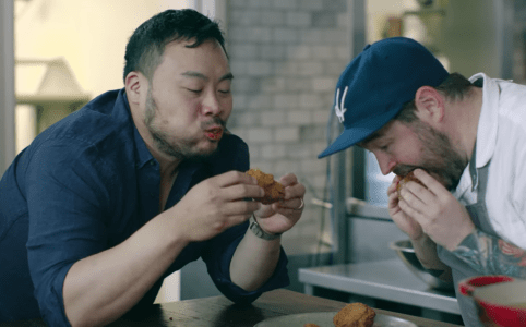 chef coreano david chang comiendo pollo frito con otro chef